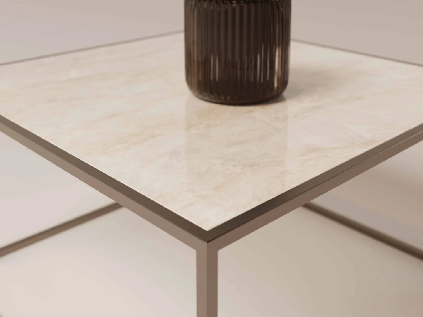 Close-up van de Salontafel Brons Rond, een minimalistische ronde tafel met een licht, glanzend marmeren blad en slanke metalen poten. Een cilindervormige vaas met donkere textuur staat aan één kant van de tafel tegen een zacht vage achtergrond.