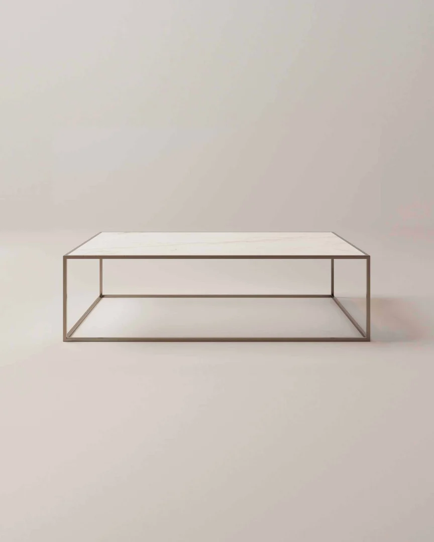 De Salontafel Brons Design is een minimalistische rechthoekige salontafel met een dun metalen frame en een glad, lichtgekleurd blad, afgebeeld tegen een effen neutrale achtergrond.
