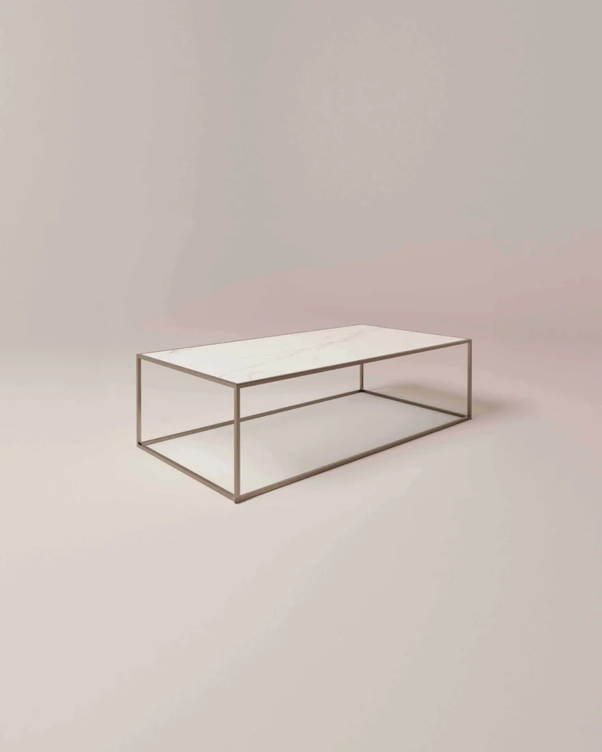 De Salontafel Brons Design is een minimalistische rechthoekige salontafel met een dun metalen frame en een wit tafelblad tegen een lichte achtergrond.