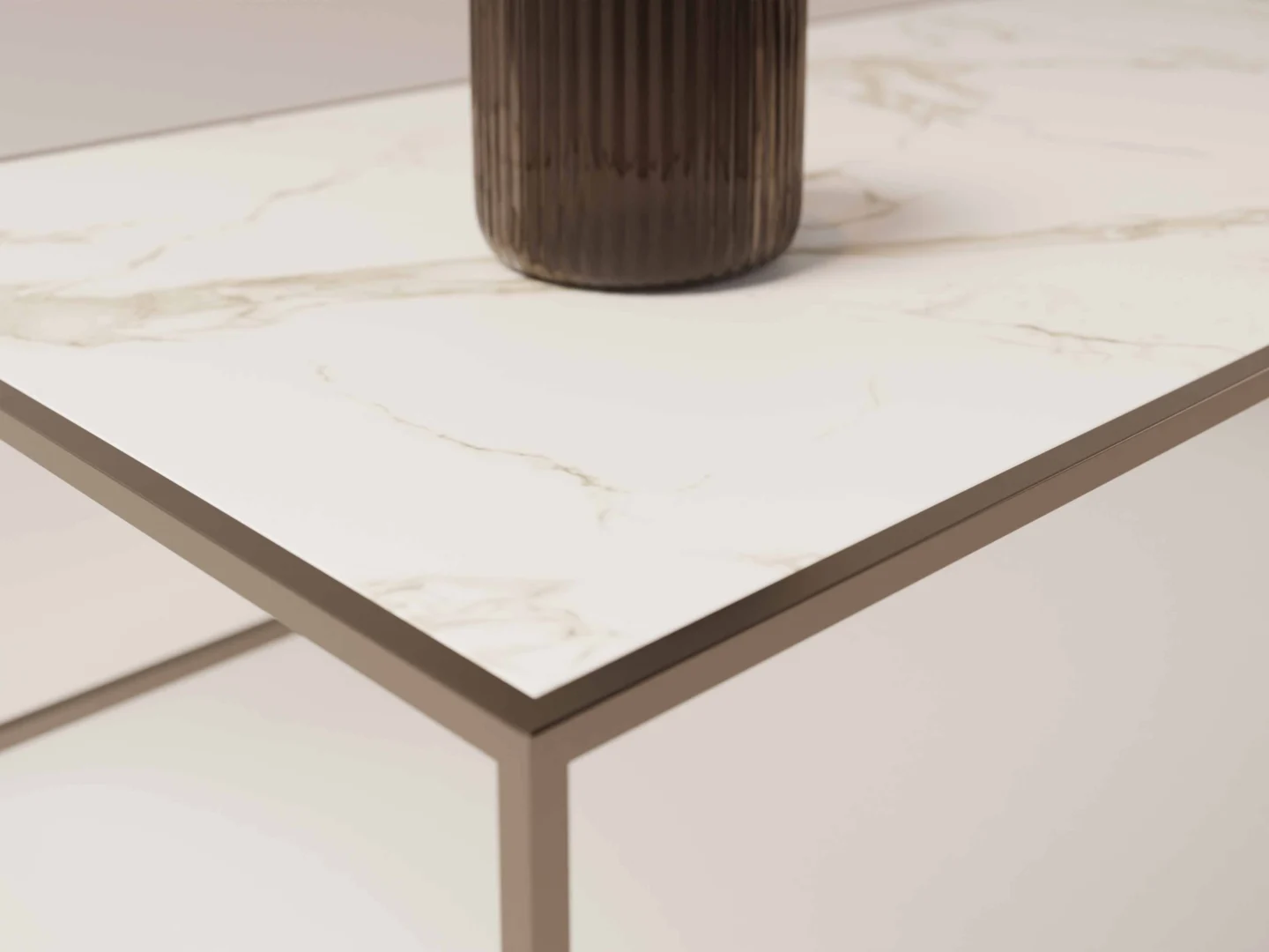 Een close-up van de Salontafel Brons Design, met een wit marmeren blad met een metalen frame en een geribbelde, donkergekleurde cilindrische vaas die gedeeltelijk zichtbaar is op het oppervlak.