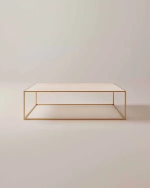 De Salontafel Messing Tijdloos Design heeft een minimalistisch licht houten blad en een slank goud metalen frame, tegen een effen, lichtgekleurde achtergrond.