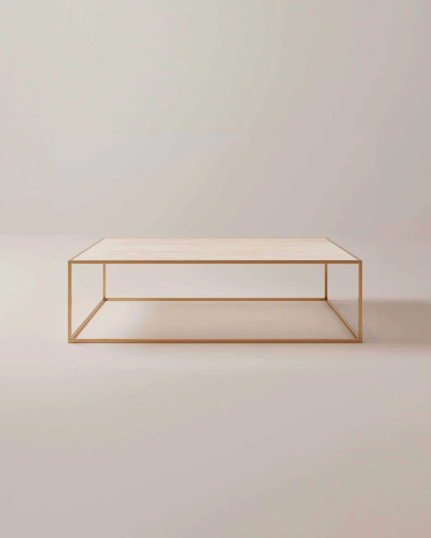 De Salontafel Messing Tijdloos Design heeft een minimalistisch licht houten blad en een slank goud metalen frame, tegen een effen, lichtgekleurde achtergrond.
