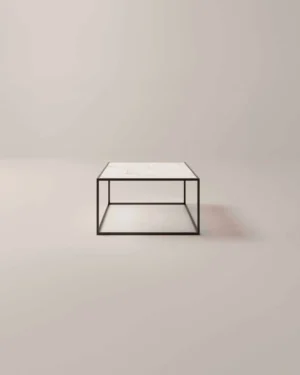 De Salontafel Zwart Design Tijdloos Design is een minimalistische vierkante salontafel met een wit marmeren blad en een dun zwart metalen frame, geplaatst tegen een effen lichtgekleurde achtergrond.