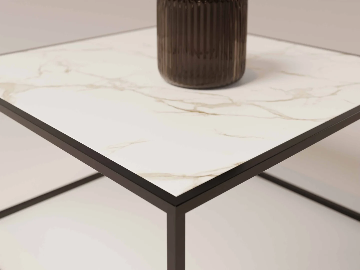 Close-up van de Salontafel Zwart Design Tijdloos: een vierkante tafel met een blad in wit marmerpatroon en een onderstel van zwart metaal. Een geribbelde, donkere vaas is gedeeltelijk zichtbaar op de tafel, met een zacht vage achtergrond.