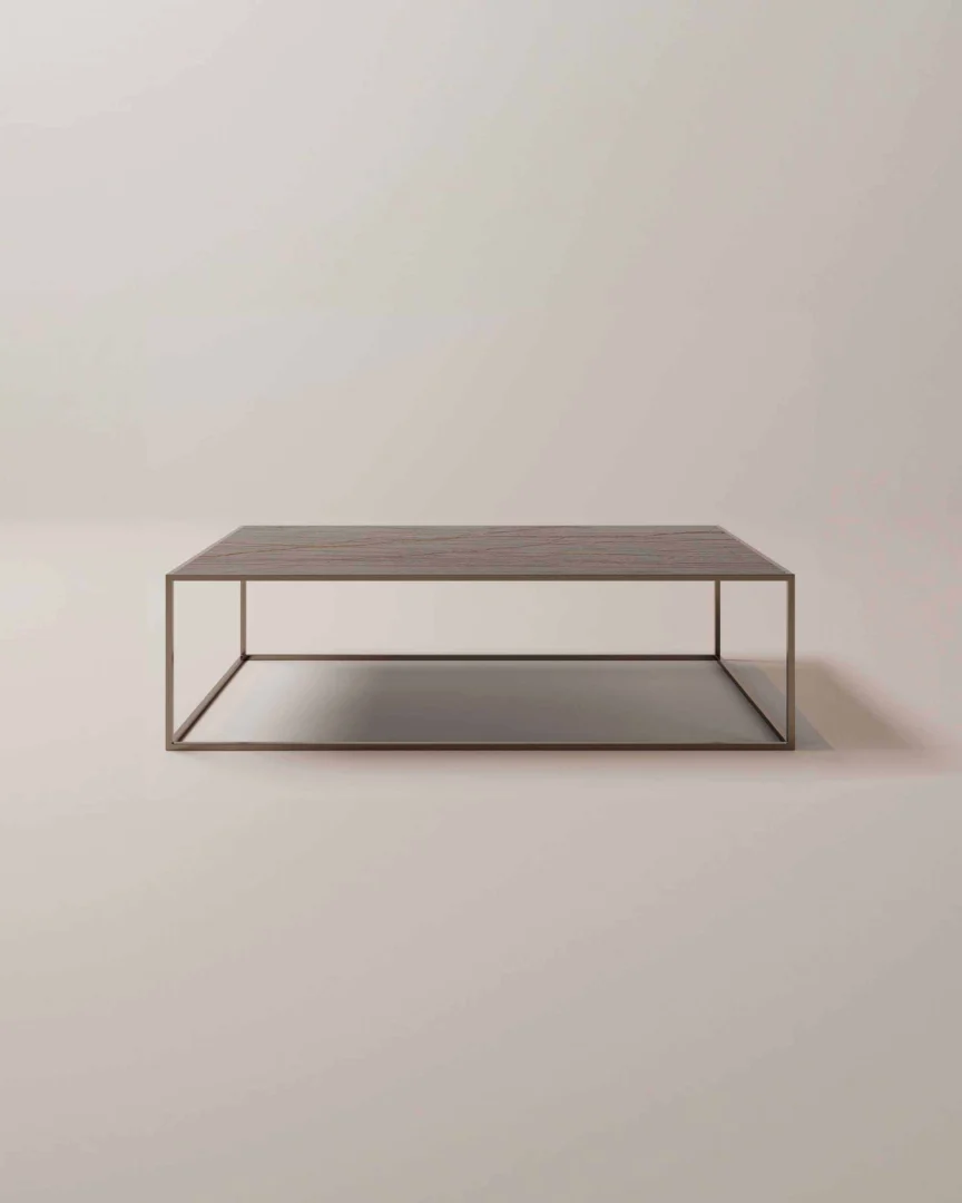 De Salontafel Brons van Roest Design is een minimalistische rechthoekige salontafel met een dun metalen frame, een plat houten blad en een open plank eronder, tegen een lichte achtergrond.