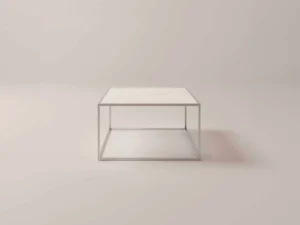 De Salontafel Zilver Keramiek is een minimalistische vierkante salontafel met een wit keramisch blad en een slank metalen frame, tegen een lichte achtergrond.