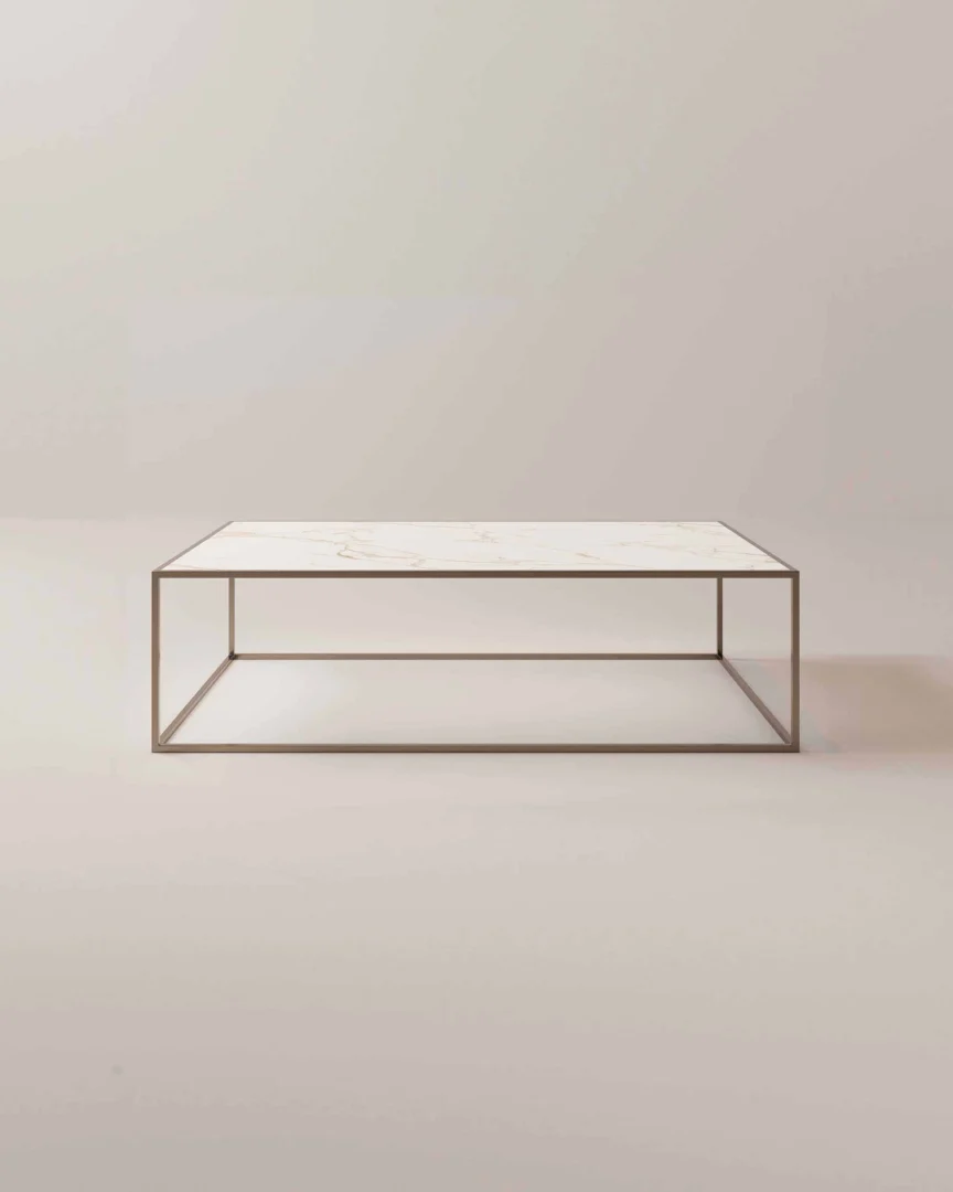 De Salontafel Brons Chique is een minimalistische salontafel met een dun, rechthoekig metalen frame en een licht marmeren blad tegen een neutrale achtergrond.