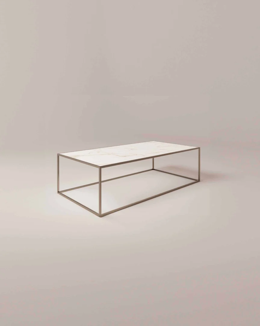 De Salontafel Brons Chique is een minimalistische rechthoekige salontafel met een dun metalen frame en een licht marmeren tafelblad, tegen een neutrale achtergrond die het moderne ontwerp benadrukt.