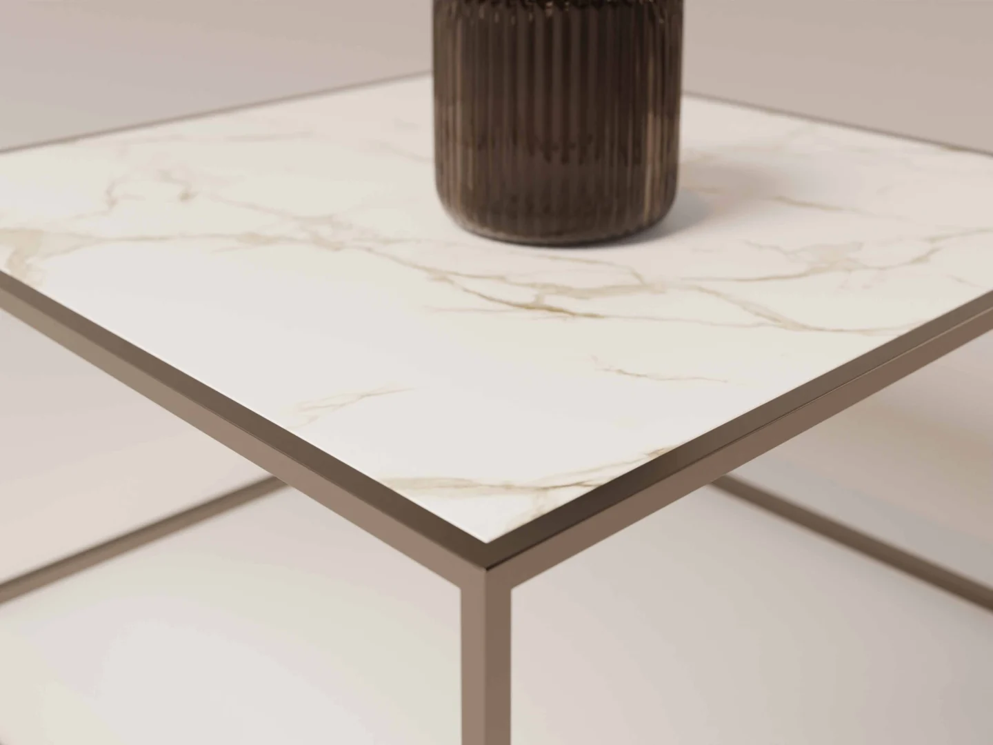 De Salontafel Brons Compact heeft een wit marmeren blad en een metalen frame. Een donkere geribbelde vaas staat in de hoek, waarbij de afbeelding de marmeren textuur en het strakke moderne ontwerp van de tafel benadrukt.