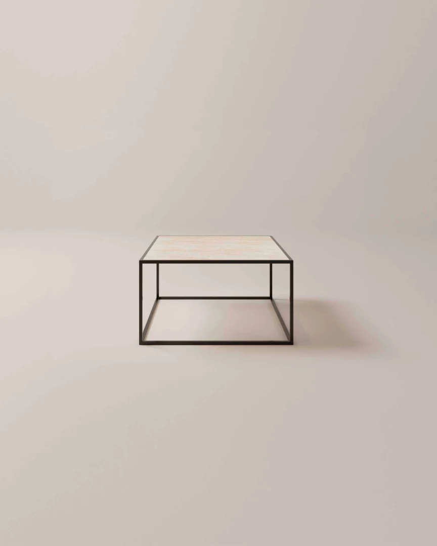 De Salontafel Zwart Design is een minimalistische vierkante salontafel met een licht blad en een strak zwart metalen frame, afgebeeld tegen een effen, lichte achtergrond.