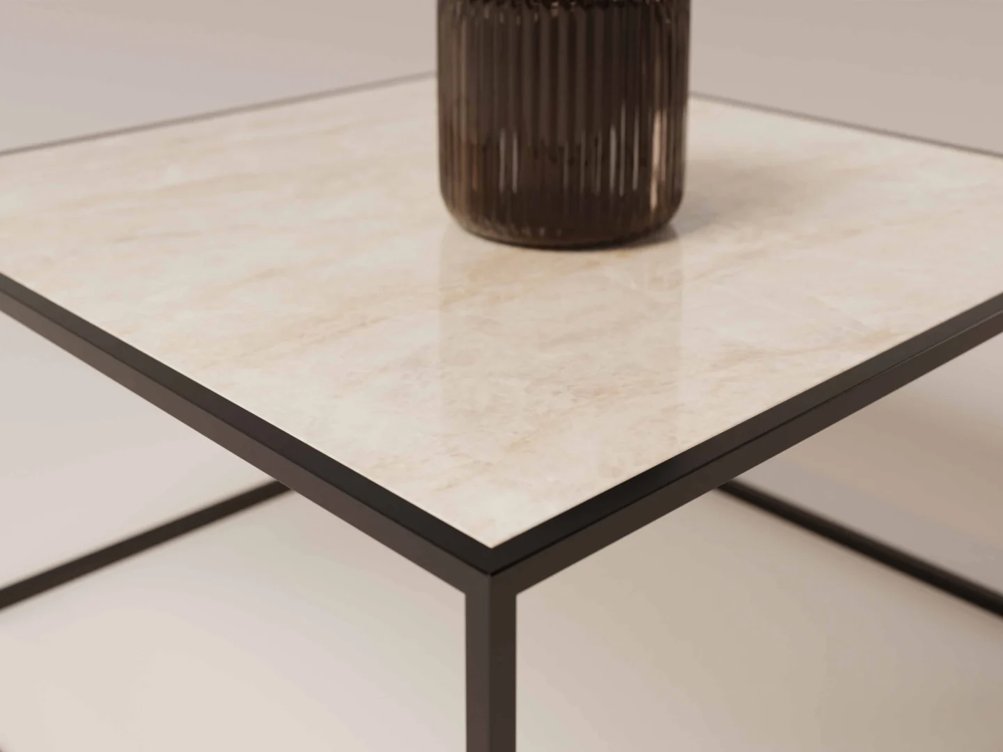 Een close-up van Salontafel Zwart Design, met een vierkant licht marmeren blad en een strak zwart metalen onderstel. Een vaas van donker geribbeld glas rust op de tafel, met een zacht vage achtergrond.