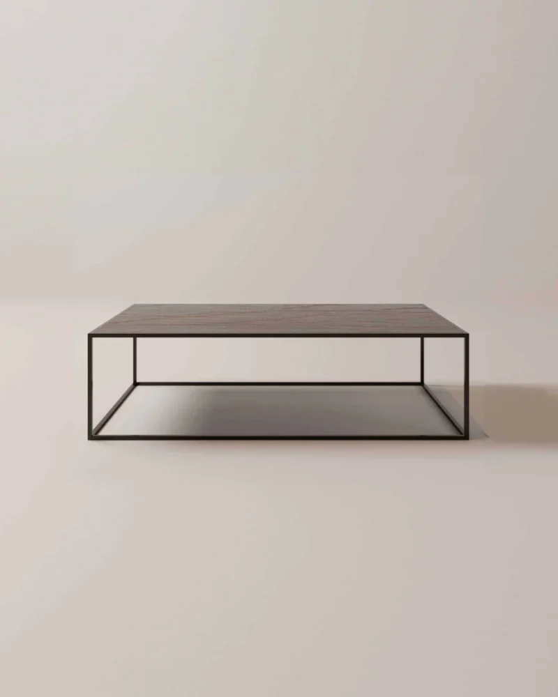 De Salontafel Zwart, Roest Rond is een minimalistische salontafel met een donker metalen frame en een plat houten blad, met een open doosachtig ontwerp. Afgebeeld tegen een effen lichte achtergrond.