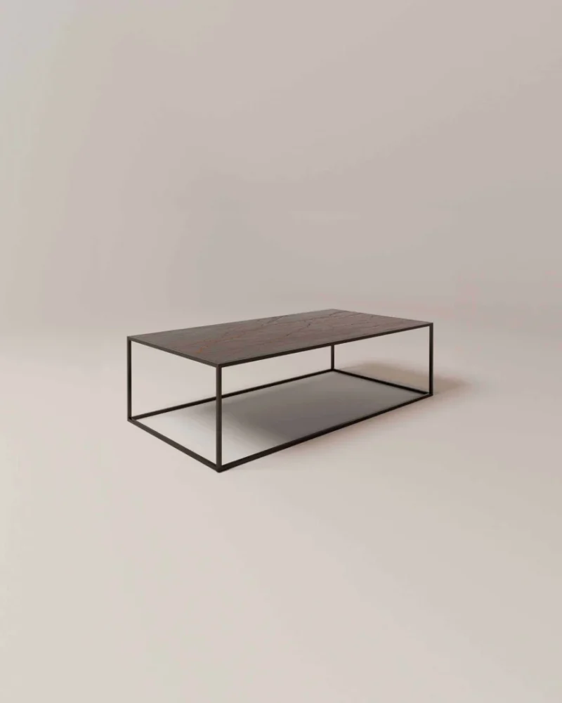 De Salontafel Zwart, Roest Rond is een minimalistische salontafel met een donker houten blad en een slank zwart metalen frame, gestileerd op een licht oppervlak en tegen een eenvoudige achtergrond.