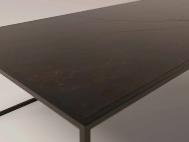 Een close-up van Salontafel Zwart, Roest Rond toont het gladde, donkerbruine rechthoekige oppervlak met slanke zwarte metalen poten tegen een lichte achtergrond.