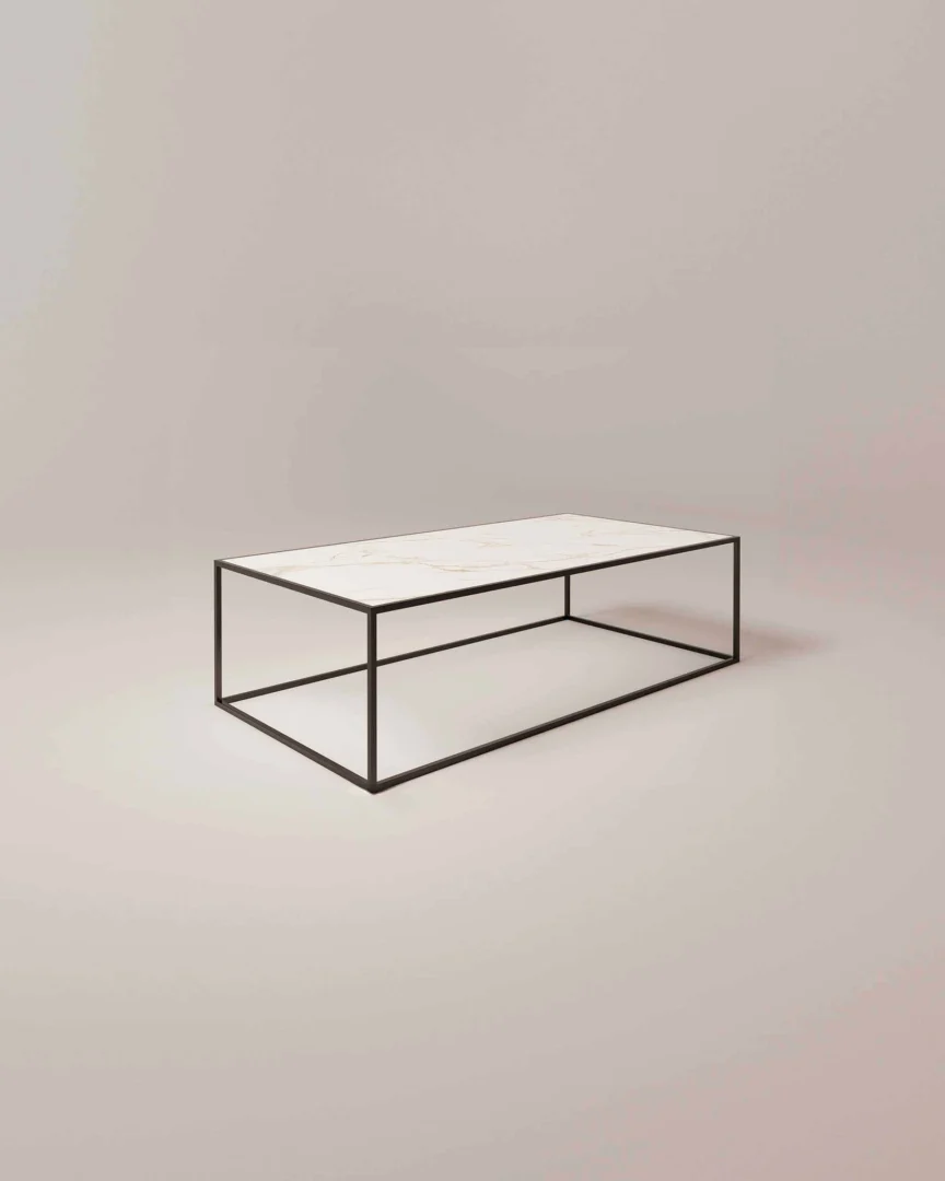 De Salontafel Zwart Design is een minimalistische rechthoekige salontafel met een wit marmeren blad en een zwart metalen frame tegen een effen, lichtgekleurde achtergrond.