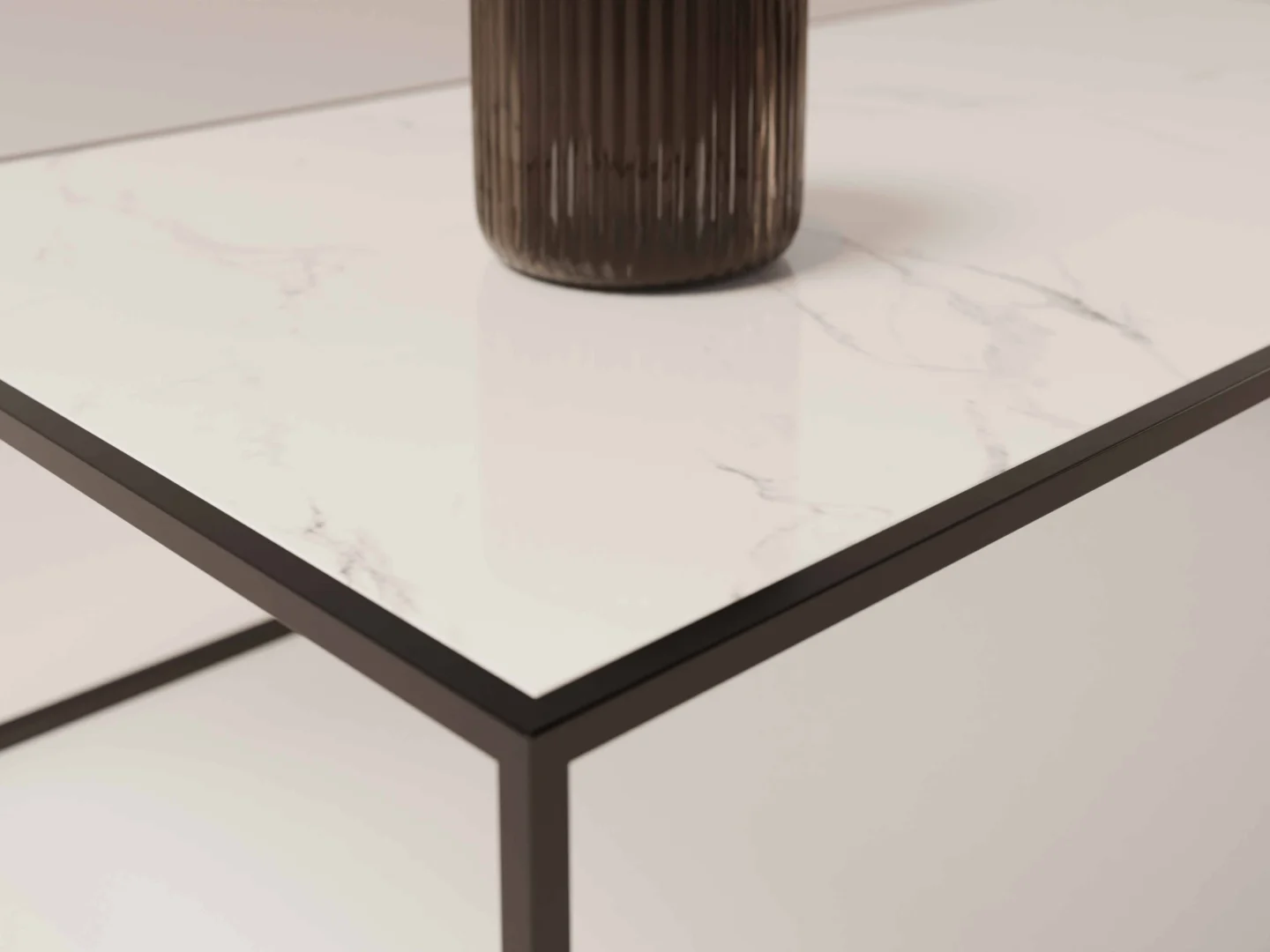 Een close-up van Salontafel Zwart Design, met een wit marmeren blad met een dun onderstel van zwart metaal en een geribbelde bruine vaas erop, in een minimalistische stijl.