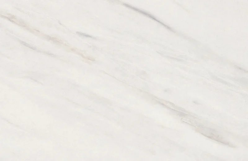 Een close-up van de Salontafel Wit 130 x 70 CM Marmer toont het witte marmeren oppervlak met subtiele grijze en beige diagonale aderen, waardoor een gladde en elegante textuur ontstaat.
