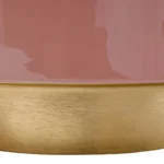 Close-up van de Bijzettafel Roze Rond Ijzer Design: een glanzend roze cilindrische bijzettafel met een brede, mat gouden metallic band aan de basis. Het licht weerkaatst op het oppervlak en creëert subtiele highlights en schaduwen.