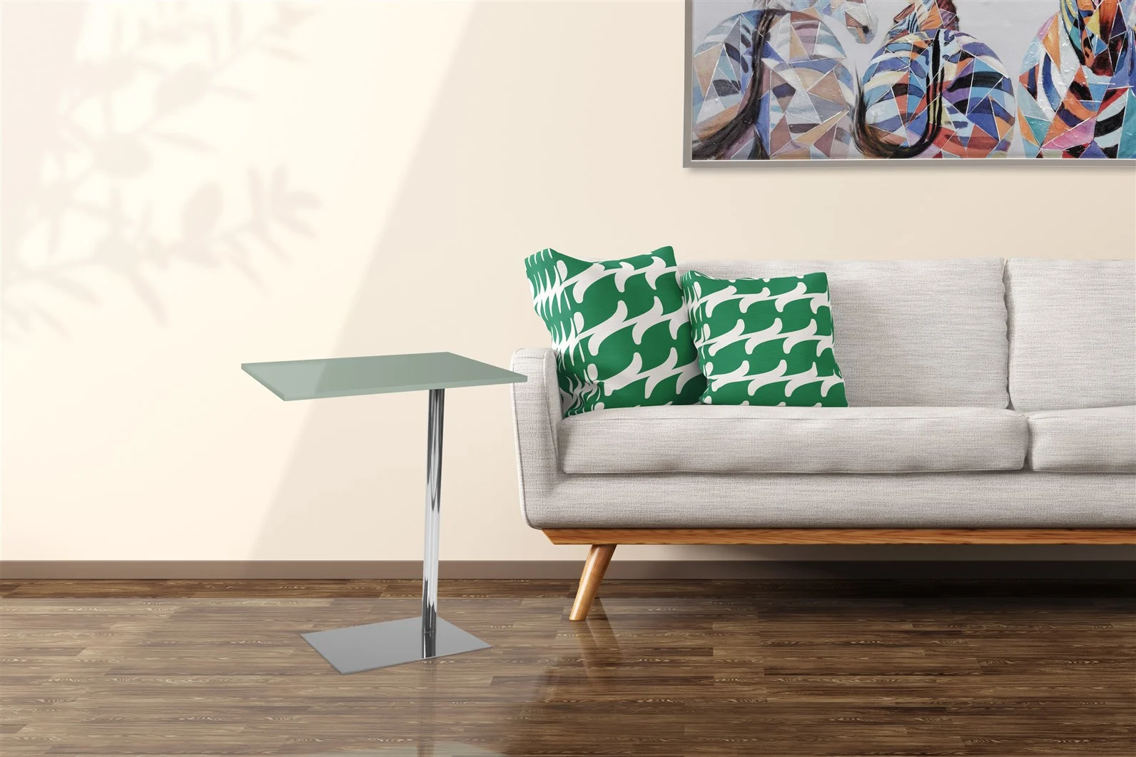 Een moderne woonkamer met een lichtgrijze bank, twee kussens met groen-wit patroon, een Bijzettafel Zilver, Grijs Metaal en een kleurrijk abstract schilderij aan de muur boven een houten vloer.