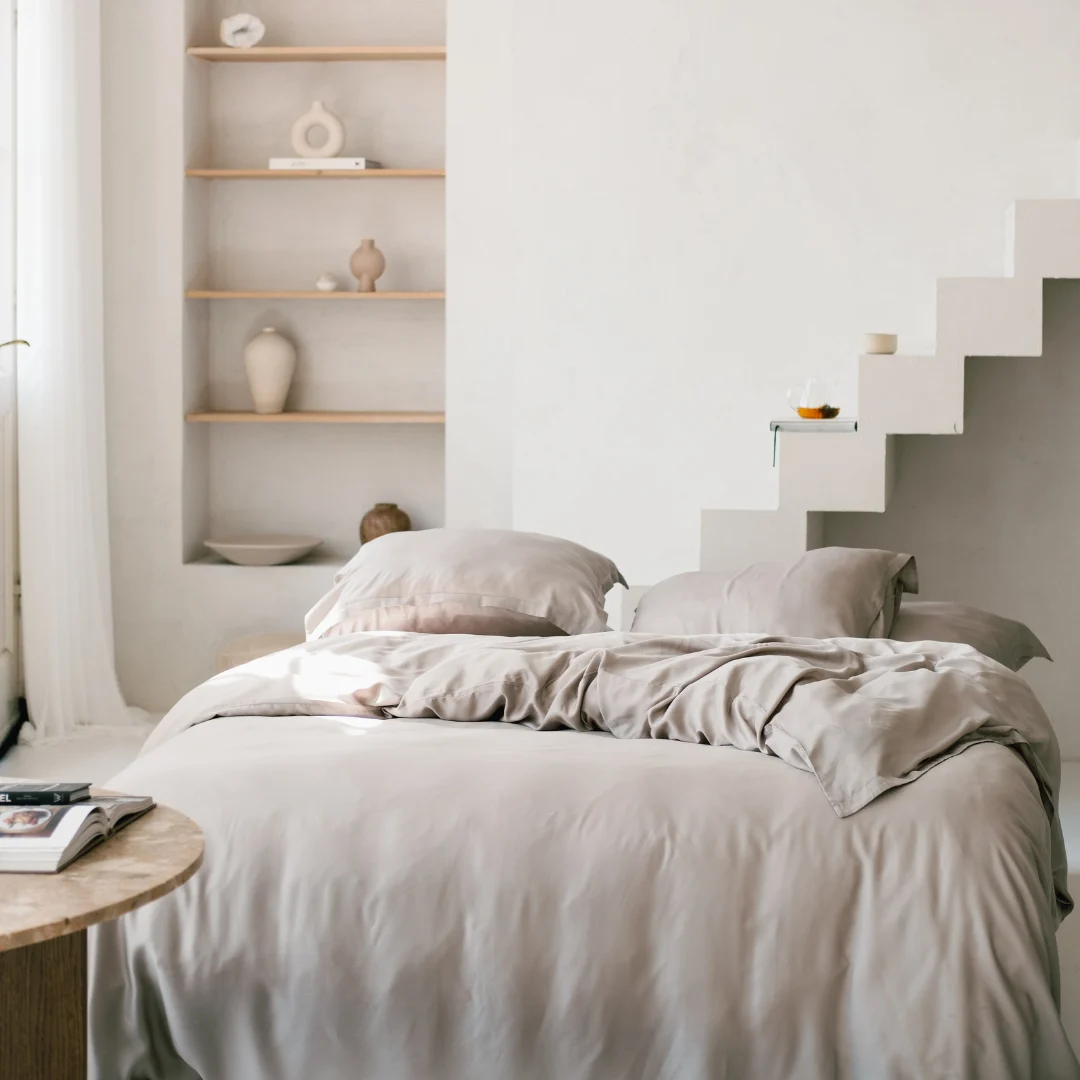 Beige beddengoed van Tencel, zacht en koel. Lichte kamer met houten details en trap. Optimale sfeer voor een goede nachtrust.