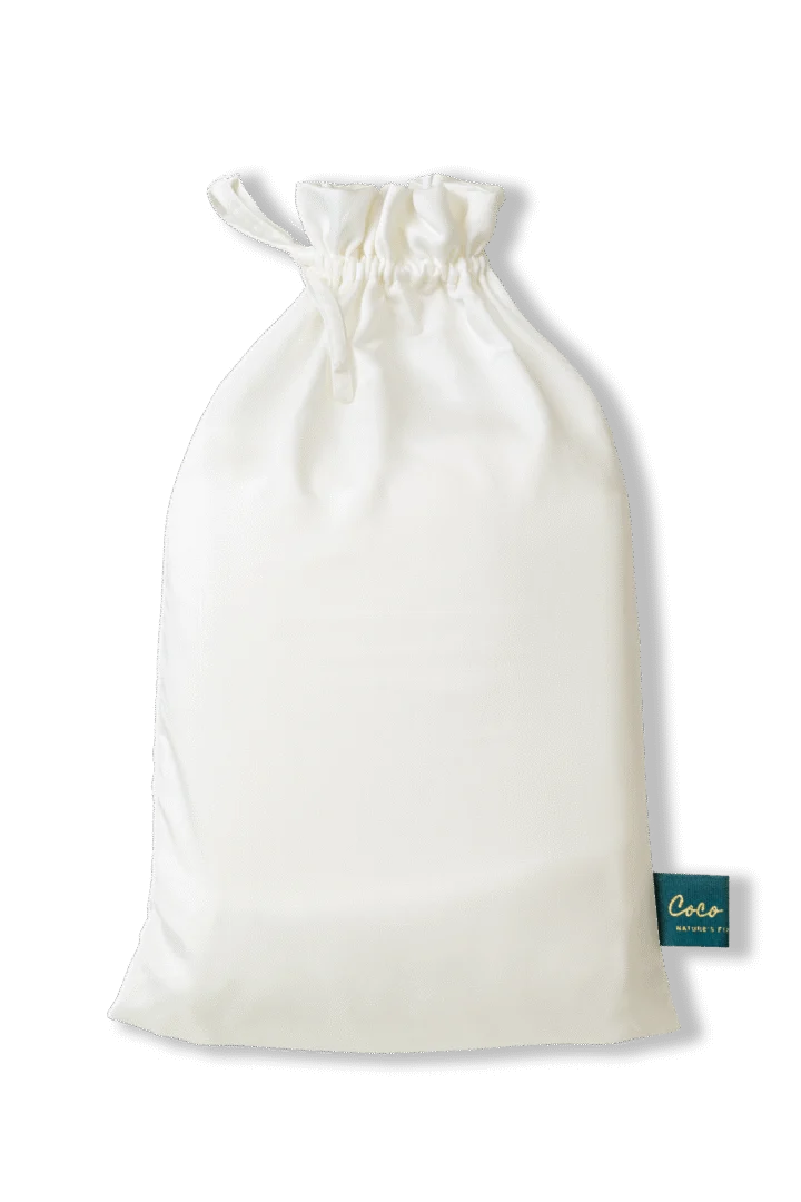 Een witte stoffen zak, close-up, met een label in de hoek. Zachte belichting, ideaal voor het verpakken van een Tencel hoeslaken.