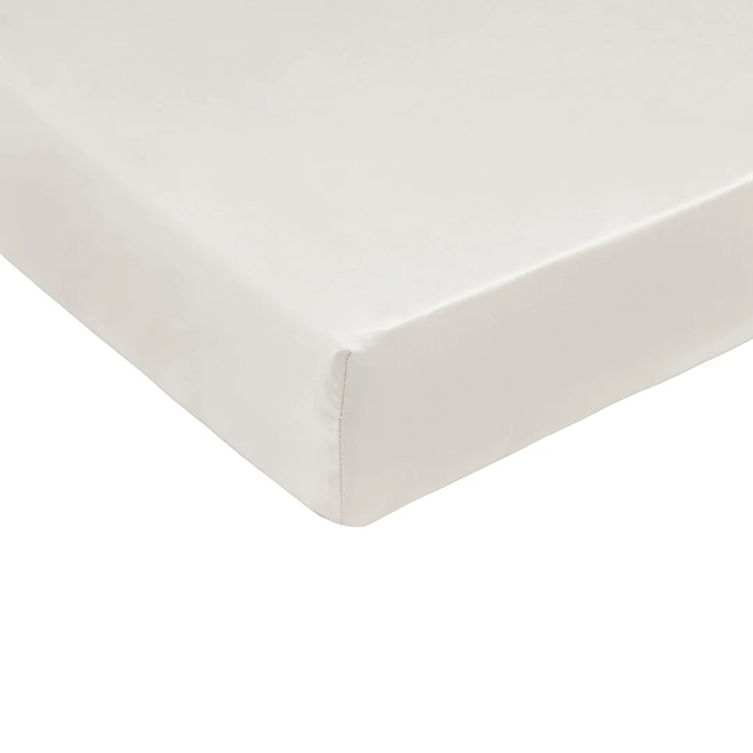 Detailopname van een wit hoeslaken, gladgestreken, met een zachte glans. Lichte schaduwen suggereren een zachte stof. Witte achtergrond.