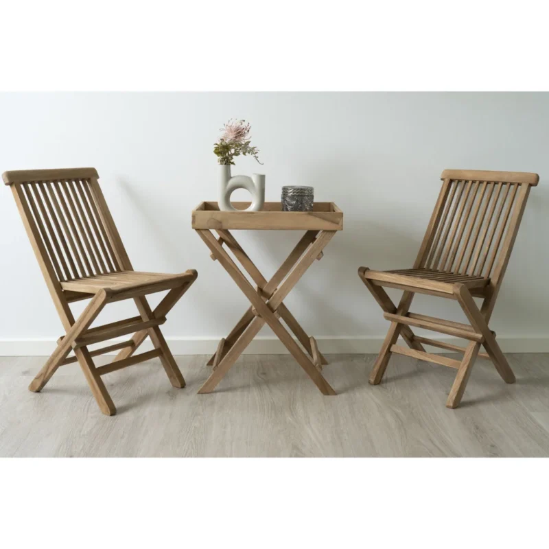 De Ronda Teak Dienbladtafel (29x39x49,5 cm) staat met twee houten klapstoelen op een lichte vloer. Op de tafel staan een witte vaas met bloemen en twee decorstukken tegen een effen witte muur.