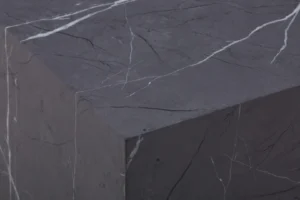 Een close-up van de Bijzettafel Grijs MDF Design toont de scherpe hoek en het gladde donkergrijze oppervlak met witte aderen die op marmer lijken.