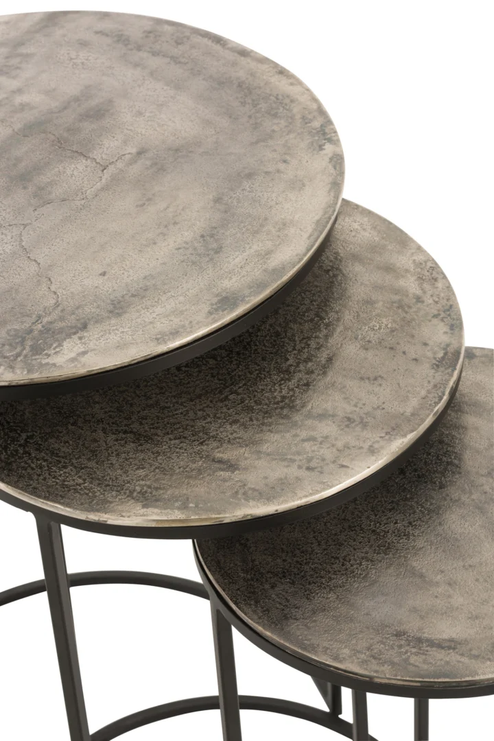 De Bijzettafel Greige, Zwart 42 x 60 CM Rond toont drie ronde aluminium nesttafels met een verweerde grijze afwerking, gerangschikt op grootte en overlappend, met zichtbare textuur en stevige donkere frames.