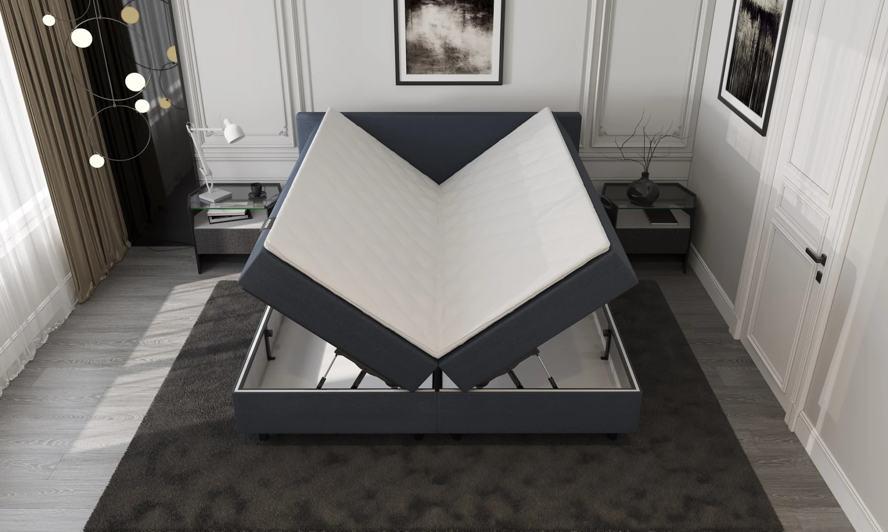 Donkerblauwe boxspring met opbergruimte open in een lichte slaapkamer. Het bed heeft een witte matras en staat op een donker vloerkleed.