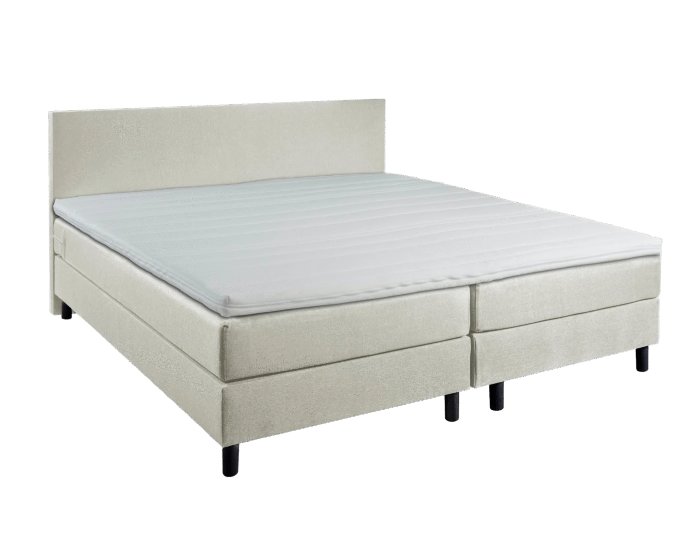 Beige boxspring met koudschuimtopper, gezien in een lichte hoek. De boxspring heeft een hoofdbord en zwarte poten.