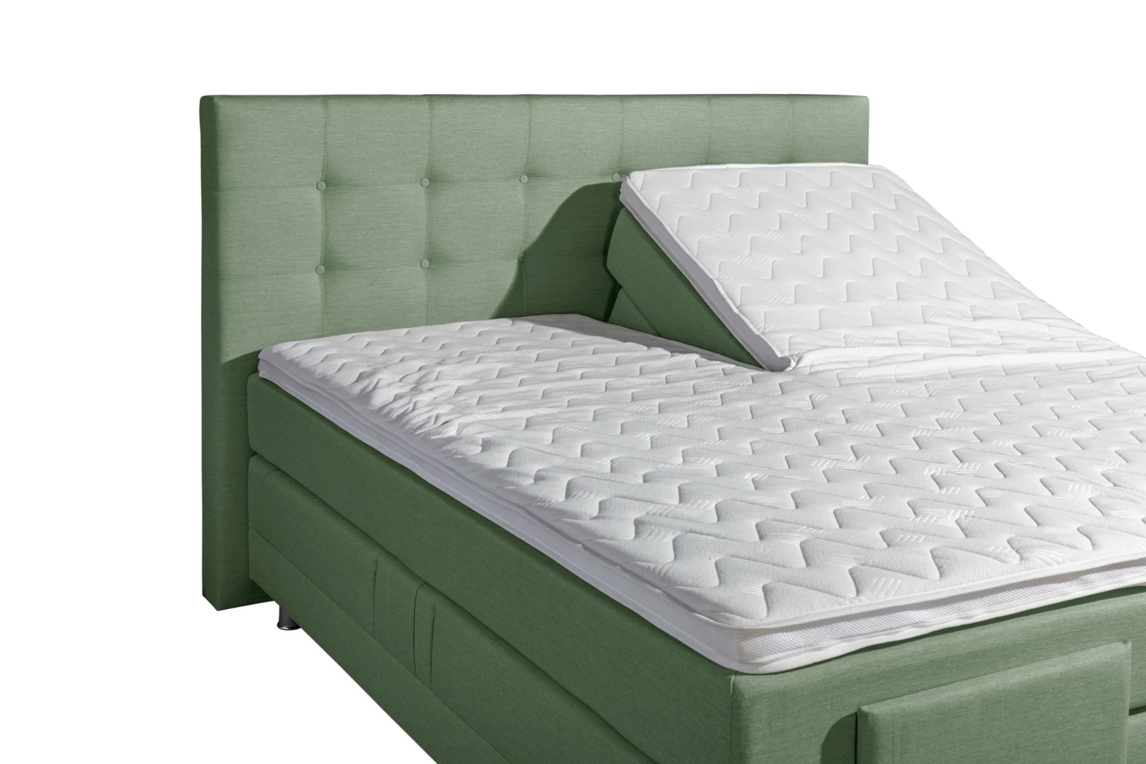 Groene stoffen boxspring met wit matras, deels omhoog. Zijaanzicht, heldere belichting. Hoofdbord met knopen.