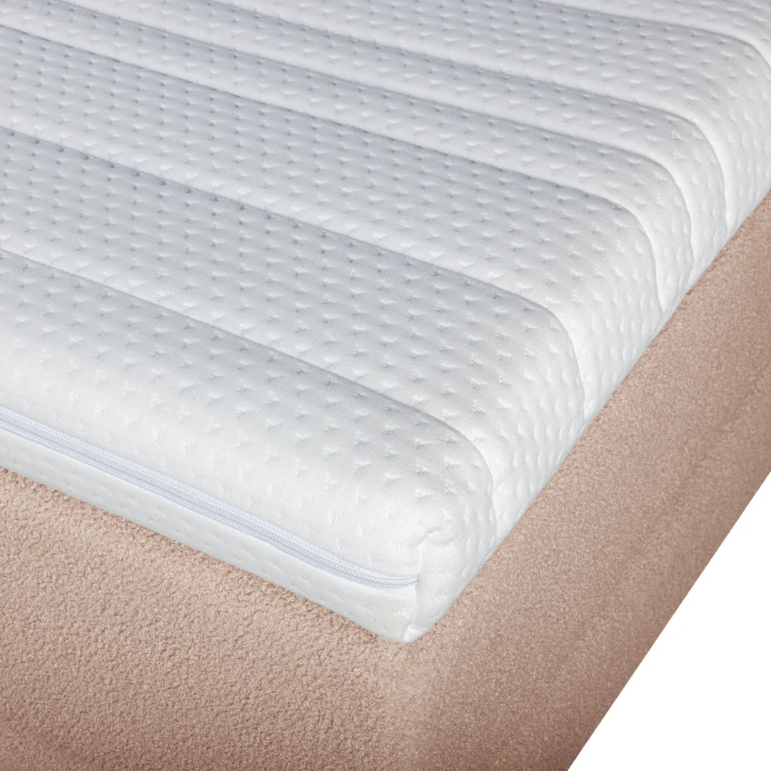 Detailopname van een pocketvering matras met HR topper, witte hoes met rits en zachtroze bouclé boxspring in helder licht.