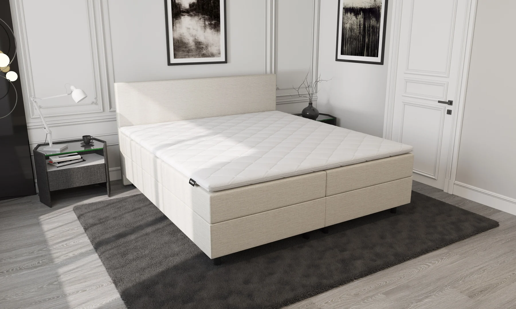 Beige boxspring met opbergruimte en pocketvering in een lichte kamer. Zijaanzicht van het bed met een wit matras en een donker vloerkleed.