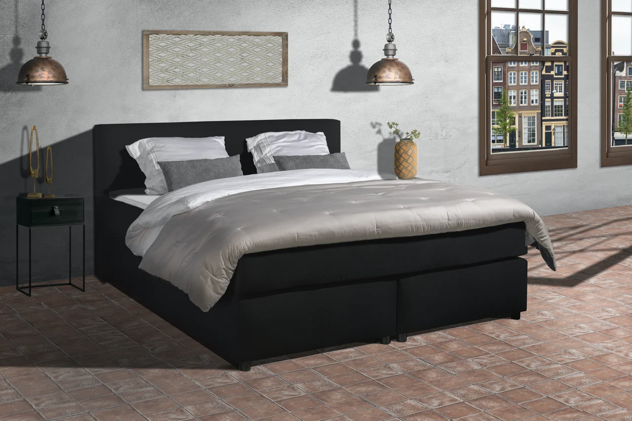 Zwarte boxspring lederlook set met pocketvering. Slaapkamer in rustieke stijl met bakstenen vloer en uitzicht op grachtenpand.