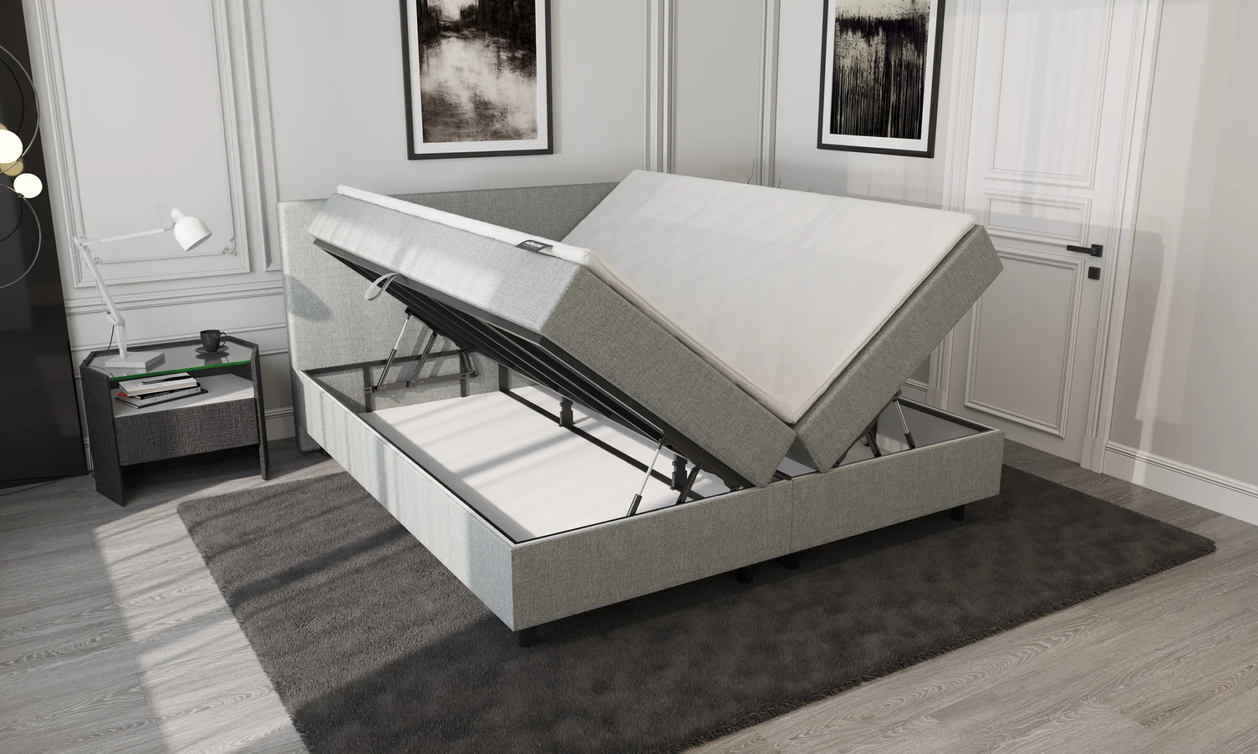 Lichtgrijze boxspring met opbergruimte openstaand. Metalen frame zichtbaar, zachte belichting, grijze vloerbedekking. Moderne slaapkamer.