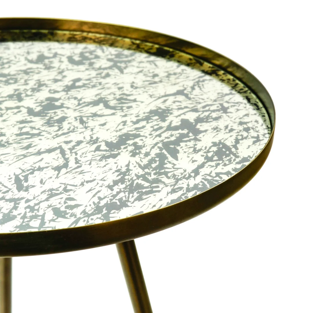 De Bijzettafel Rond Glas heeft een dun metallic goudkleurig frame met drie poten en een rond glazen tafelblad met een gemarmerd wit en grijs patroon. Het moderne, stijlvolle ontwerp steekt af tegen de effen witte achtergrond.