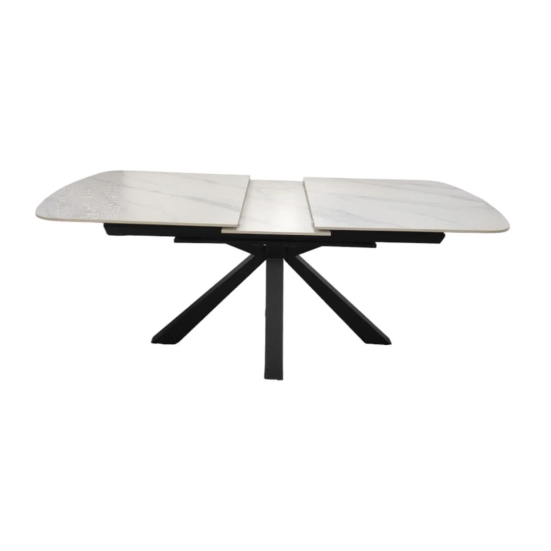 De OCTOPUS DT ZWART 160/200X90 WIT SINTERSTEEN is een moderne rechthoekige eettafel met een blad van witte gesinterde steen, zwarte metalen poten in een kruisvormig ontwerp en een uitschuifbaar middendeel.