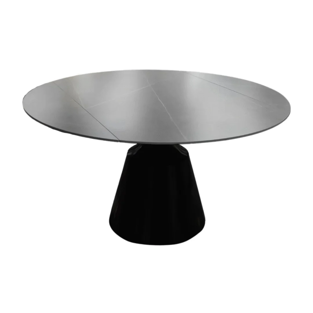 De DRAAI DT ZWART 135/86X75 heeft een moderne ronde vorm met een lichtgrijs gesinterd stenen tafelblad en een brede zwarte conische voet, afgebeeld tegen een witte achtergrond.