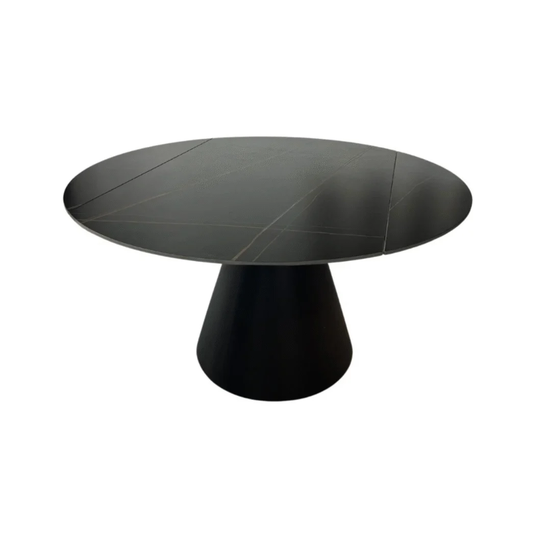 De DRAAI DT ZWART 135/86X75 ZWART/GOUD SINTERSTEEN is een moderne zwarte ronde tafel met een glad oppervlak en een brede conische voet, tegen een effen witte achtergrond.