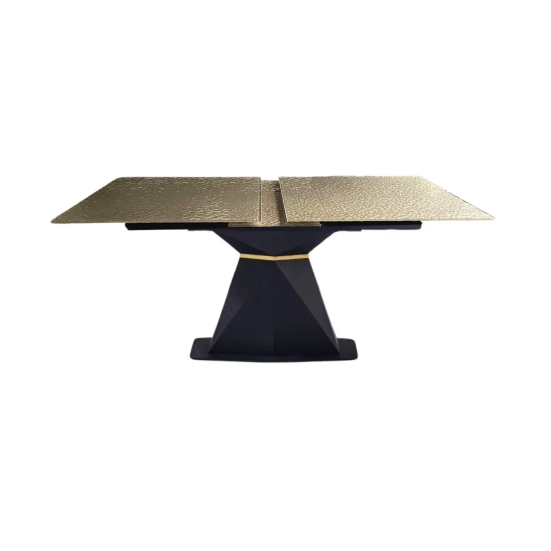 De SPRING DT ZWART 180/220x90 GOUD GEFUSEERD GLAS is een moderne eettafel met een rechthoekig blad van goudgesmolten glas en een geometrisch zwart voetstuk, afgebeeld tegen een witte achtergrond.