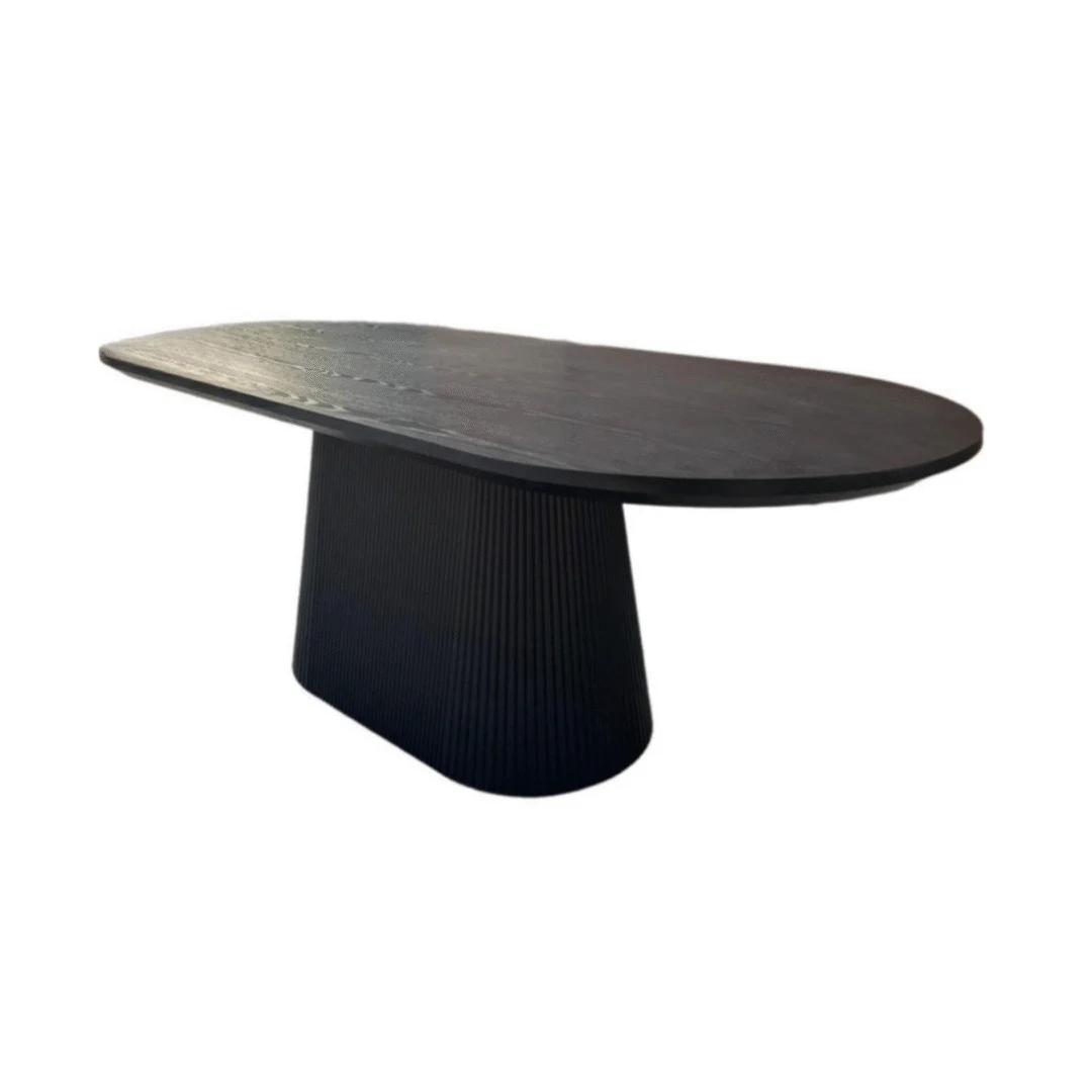 De KIMBERLY DT 180X90 + ZWART FINEER EGAAL is een moderne zwarte ovale eettafel met een glad mat tafelblad en een geribbeld sokkelonderstel met textuur, afgebeeld tegen een effen witte achtergrond.