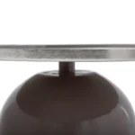 Close-up van het onderstel en de onderkant van de Bijzettafel Zilver, Grijs Rond Ijzer-een ronde metalen tafel met een reflecterend oppervlak en een glanzende, donkere sokkel.