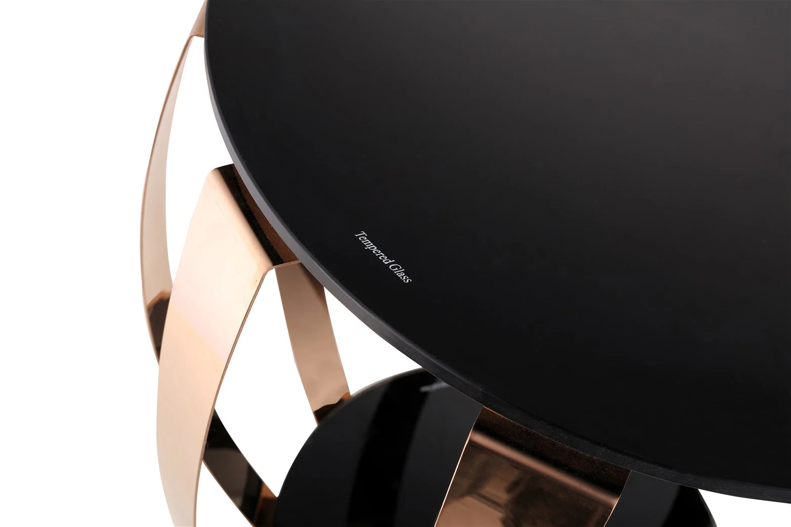 De Bijzettafel Goud Staal Compact heeft een rond zwart gehard glazen tafelblad met een klein "Tempered Glass" label en een reflecterend gouden metalen onderstel in een modern geometrisch ontwerp.