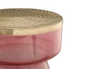 Een close-up van de Bijzettafel Goud, Roze Ijzer Compact, met een ronde vorm met een gestructureerd goudmetallic deksel en een doorschijnend roze basis, tegen een effen witte achtergrond.