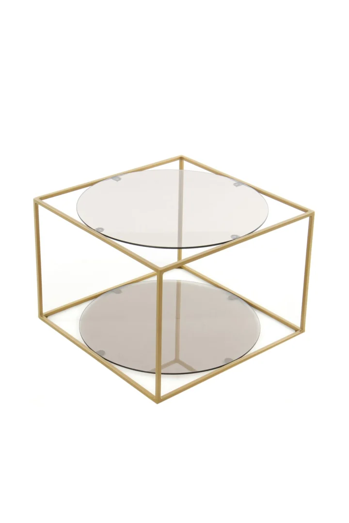 De Bijzettafel Grijs, Goud Rond Metaal is een stijlvolle ronde salontafel met een goud metalen frame en twee glazen oppervlakken - het bovenblad en de onderste plank - tegen een witte achtergrond.