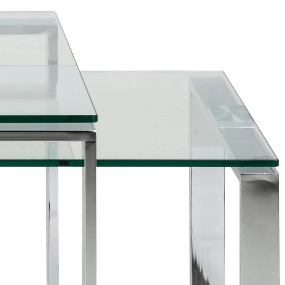 De Salontafel Transparant Rechthoek Glas set bestaat uit twee moderne, minimalistische nesttafels met bladen van helder glas en zilverkleurige metalen poten, ontworpen om elkaar gedeeltelijk te overlappen voor een strakke eigentijdse look.