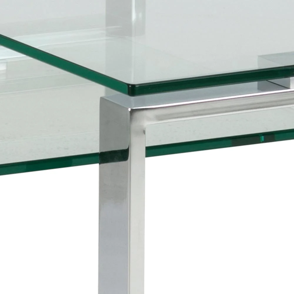 Close-up van de Salontafel Transparant Rechthoek Glas: een moderne glazen tafel met een helder rechthoekig blad en slanke zilverkleurige metalen poten, die het minimalistische ontwerp en de scherpe, strakke lijnen benadrukken.