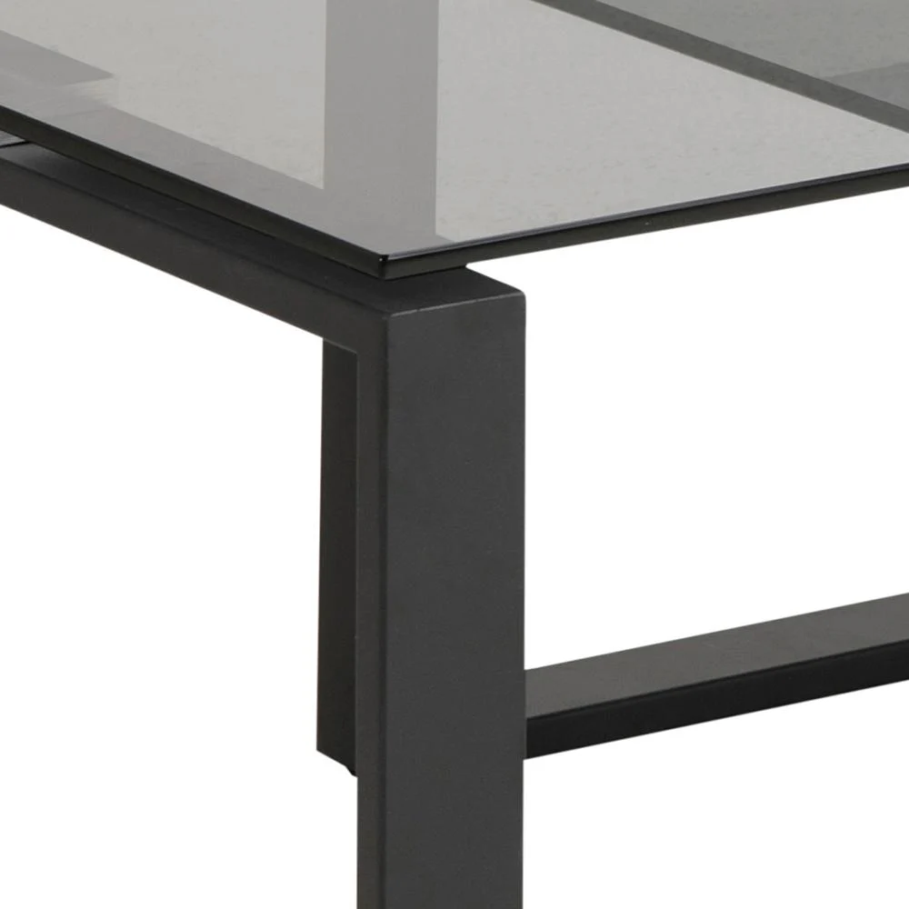Close-up van de Salontafel Rookglas, Zwart (40 x 45 CM) met een zwart metalen frame en een rechthoekig blad van gerookt glas tegen een effen witte achtergrond.