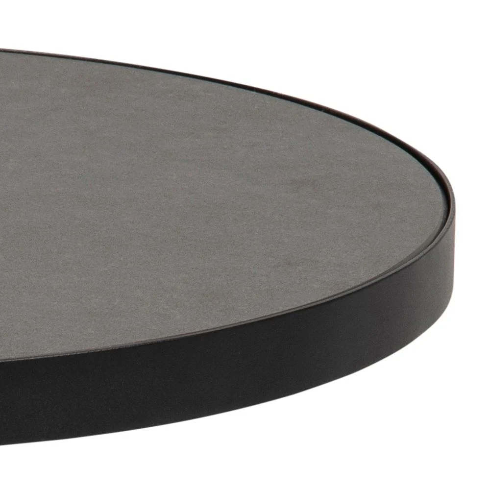 Close-up van de rand van de Salontafel Zwart 45 CM Rond Keramiek, met een glad, matzwart keramisch oppervlak met een dunne rand. Slechts een deel van het ronde tafelblad is te zien tegen een witte achtergrond.